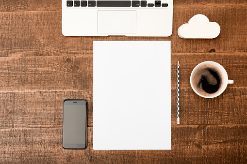 Office desk table. Top view with blank white paper, laptop, pencil and coffee  on wooden table background. Top view with copy space