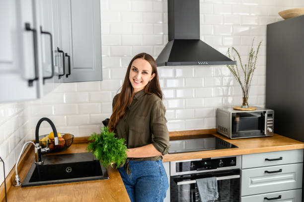 istock A woman with a bunch of dill in hands in kitchen 1223442007