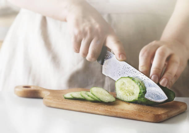 chef affettando verdure e cetriolo sul tavolo del ristorante. processo di taglio e preparazione del cibo in cucina. - silverware food and drink industry food service occupation dinner foto e immagini stock