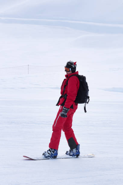 snowboarder em vermelho na encosta de esqui nevado na noite de inverno - snowboarding snowboard teenager red - fotografias e filmes do acervo