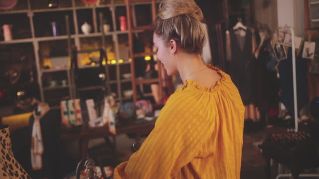 Blonde woman shopping for swimsuits in a vintage boutique store