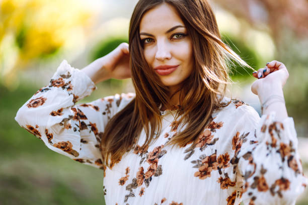 istock Beautiful young woman near the blooming spring tree. Springtime. 1223446350