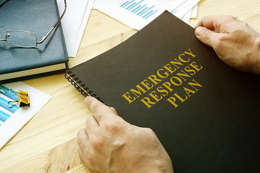 El hombre abre el plan de respuesta ante desastres y emergencias para la lectura. photo