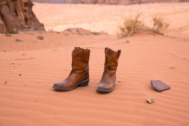 botas de couro marrom-vermelho ficar em uma colina de deserto de areia. não há pessoas por perto. - sandy brown day the americas north america - fotografias e filmes do acervo