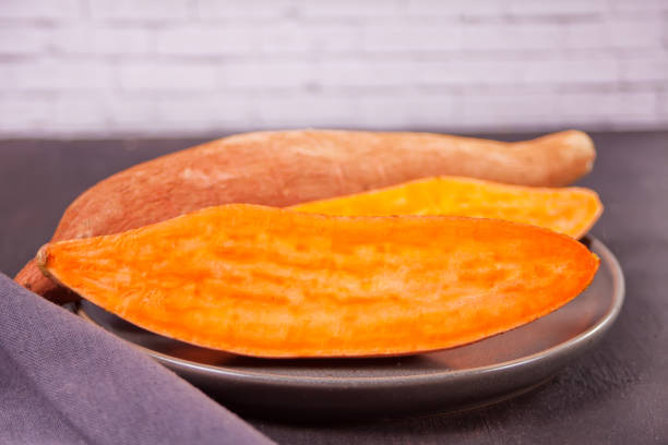 istock Raw sweet potatoes on the black table. 1223449663
