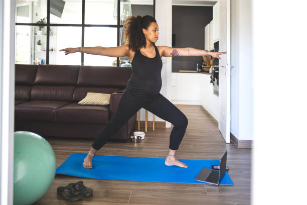 istock Pregnant woman practicing Yoga with online video class 1223450059