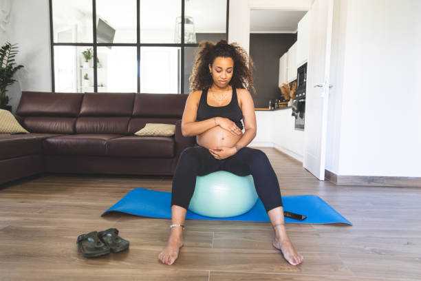 istock Pregnant woman practicing Yoga with online video class 1223451687