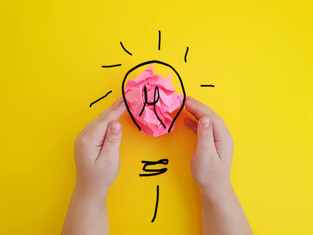 istock hands child crumpled paper ,   idea  on a colored background 1223454942