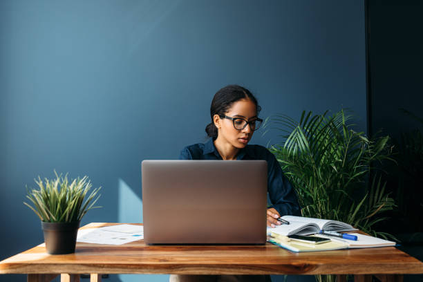 istock Thoughtful young woman looking at documents in home office. Entrepreneur working remotely. 1223473028