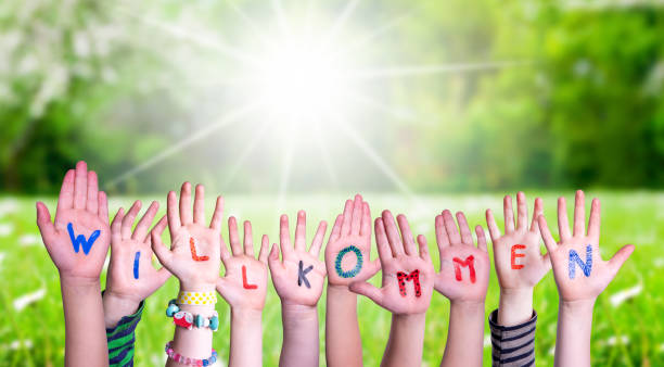 istock Children Hands Building Word Willkommen Means Welcome, Grass Meadow 1223477642