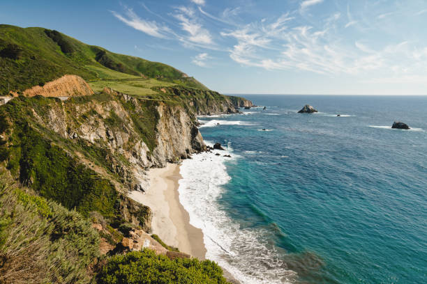Big Sur, a popular touristic destination, famous for its dramatic scenery. Stunning view of  Pacific Ocean, Rocky cliffs, and beautiful sandy beach. Monterey County, California Scenic view of ocean, and rocky cliffs. Big Sur, California Bixby Creek stock pictures, royalty-free photos & images