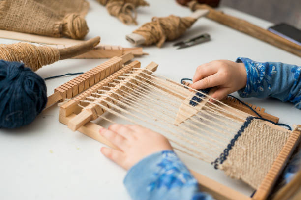 istock A little girl learns process to weave thick threads. Hands close up. Creating a picture by weaving. 1223478583