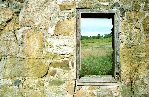 A window in the last remaining wall of a crumbling house.
