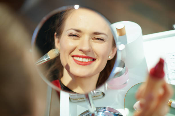 istock smiling housewife looking in mirror and using liquid foundation 1223480117