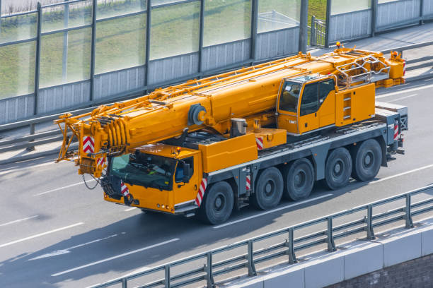 istock Heavy mobile crane with folding boom construction rides on a city highway. 1223480149