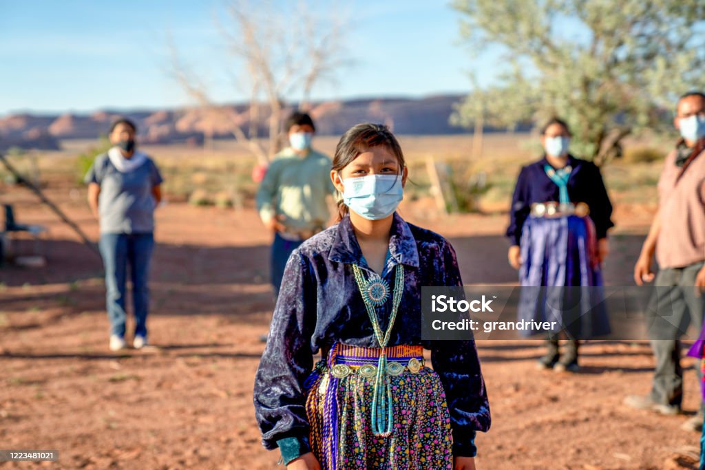 A Navajo Family Practicing Social Distancing, Wearing Masks During The Coronavirus Pandemic American indigenous family aware of the dangers of the Covid19 pandemic stands 6 feet apart from one another Indigenous Peoples of the Americas Stock Photo