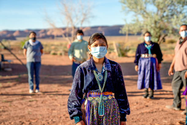 A Navajo Family Practicing Social Distancing, Wearing Masks During The Coronavirus Pandemic American indigenous family aware of the dangers of the Covid19 pandemic stands 6 feet apart from one another navajo nation covid stock pictures, royalty-free photos & images