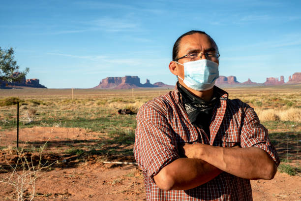 A Courageous Navajo Man Living In The Monument Valley Tribal Park Wears A Mask For Protection From Covid19 A brave Navajo father stands defiant in the wake of the Coronavirus hitting the Navajo People navajo nation covid stock pictures, royalty-free photos & images