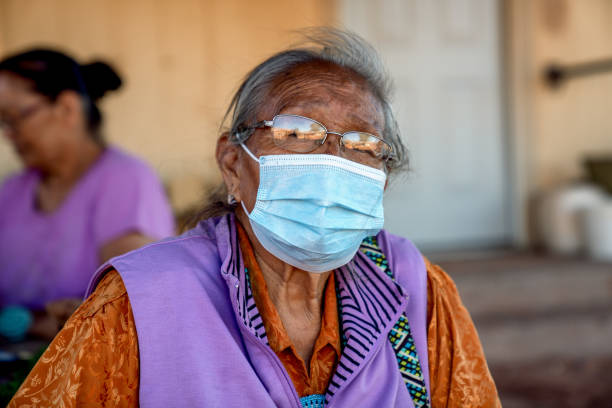 la matriarca di una famiglia navajo che indossa una maschera a casa sua sulla riserva, monument valley, covid19 - adult senior adult traditional culture usa foto e immagini stock