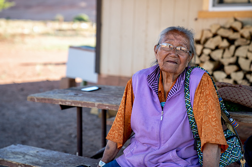 An elderly Navajo grandmother and Matriarch at her home, smiling sweetly