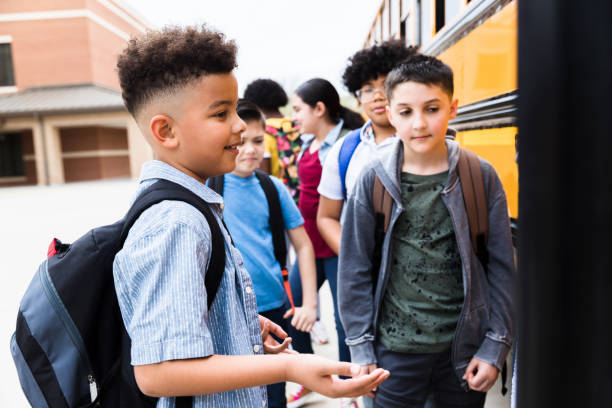 istock Elementary age boy talks with unseen person on bus steps 1223481692
