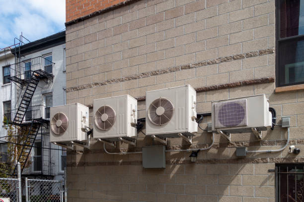 istock residential building brick side wall with serval Air conditioning chllers unites and piping 1223482829