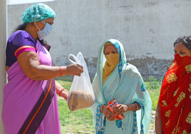 india: trabajador anganwadi distribuye trigo a personas pobres - women poverty senior adult mature adult fotografías e imágenes de stock