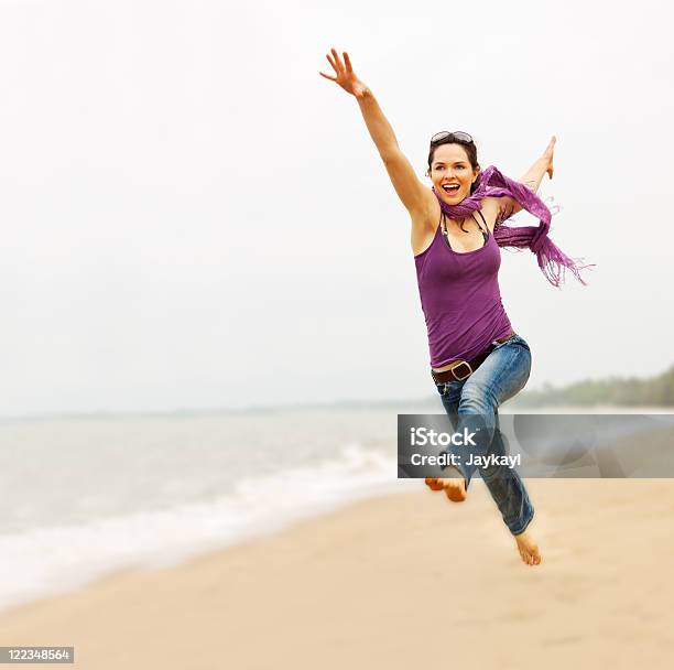 Beautiful Young Woman Taking A Great Leap On The Beach Stock Photo - Download Image Now
