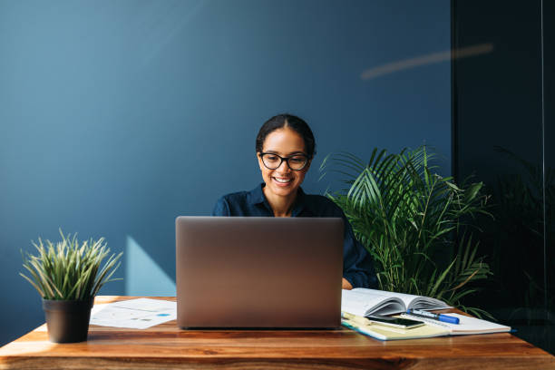 istock Smiling entrepreneur sitting at home working on laptop computer with documents on the table 1223487266
