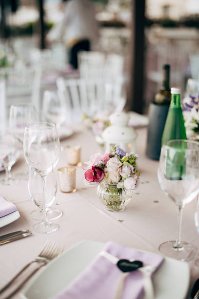 istock Wedding dinner table reception. A small glass case with rose flowers stands on the table in the form of decoration. 1223487358