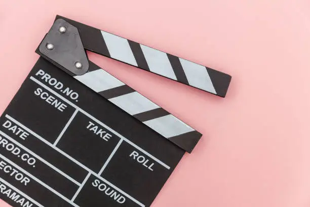Filmmaker profession. Classic director empty film making clapperboard or movie slate isolated on pink background. Video production film cinema industry concept. Flat lay top view copy space mock up