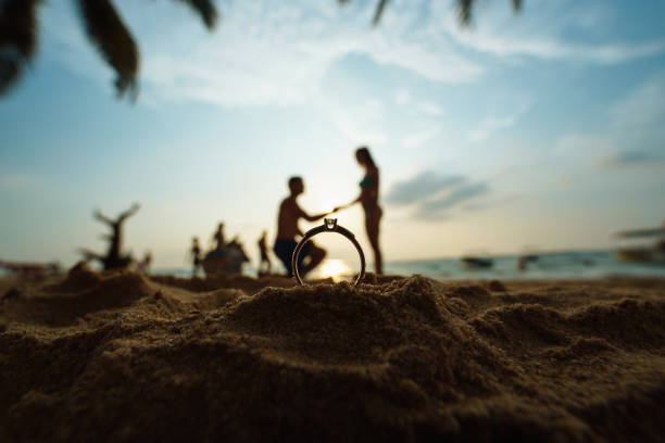 Proposal on the beach with a man asking for marry at sunset.