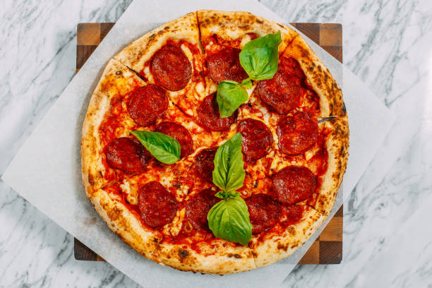 istock Italian pizza with mozzarella cheese and basil on a marble table 1223488521