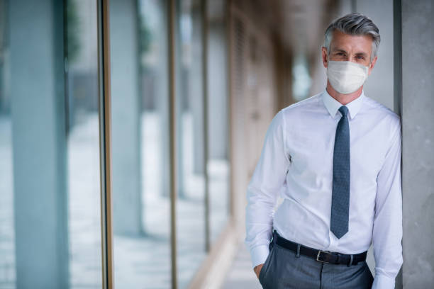 istock Successful business man wearing a facemask at the office 1223488537