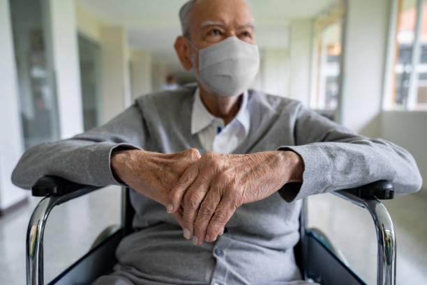 adulto mayor en silla de ruedas en el hospital con una mascarilla - one person lifestyles 80 plus years indoors fotografías e imágenes de stock