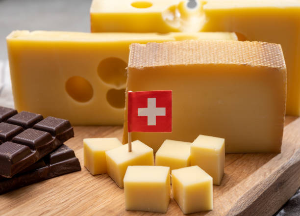 tasty swiss food, block of medium-hard yellow cheese emmental or emmentaler with round holes, matured gruyere and high quality milk chocolate - cheese emmental cheese switzerland grated imagens e fotografias de stock