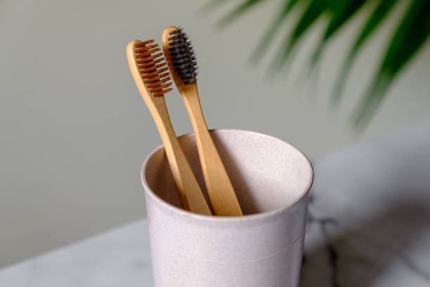 istock Cup with organic bamboo toothbrushes on table, close up view. Dental care concept. 1223489583