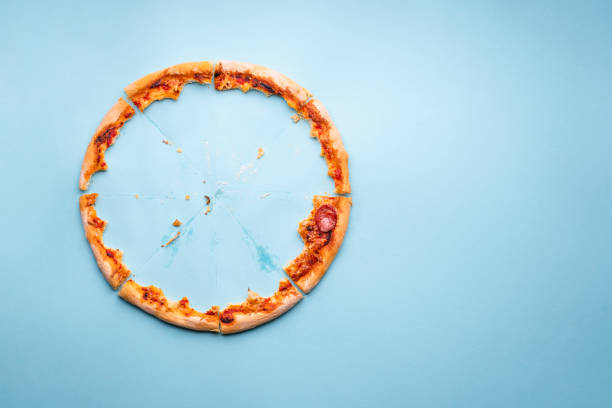 istock Pizza crust leftovers on blue paper background, top view 1223491215