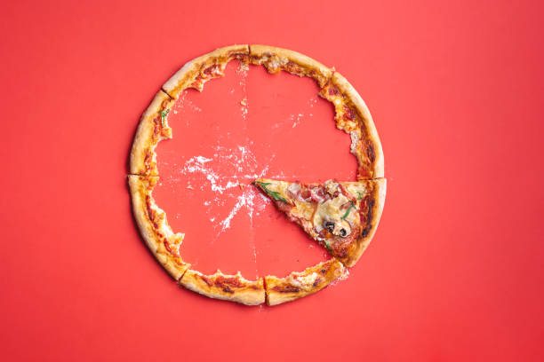 istock Single slice of pizza and crumbs on a red background 1223491341