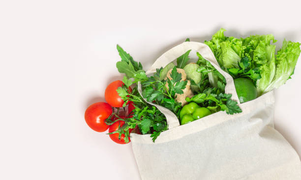 istock Textile eco bag with various fresh organic vegetables on a white background 1223491401