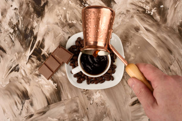 istock Top view. Pouring black coffee from cezve to a cup. 1223494259