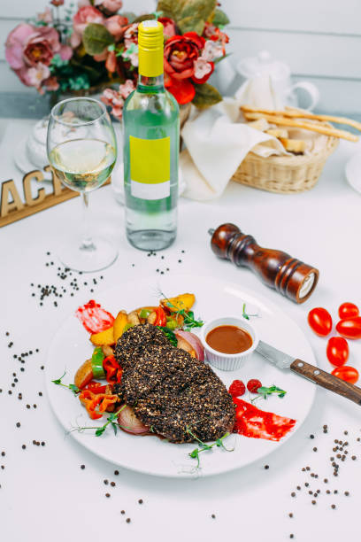 pepper steak with grilled vegetables with sauce on an isolated white background