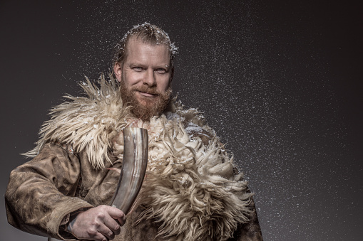 Portrait of an individual snowy Viking warrior king alone in studio shoot