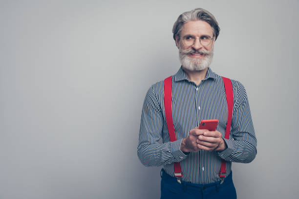 istock Portrait of his he nice attractive classy confident curious cheerful cheery man using cell app 5g creating new media post share isolated over gray pastel color background 1223499889