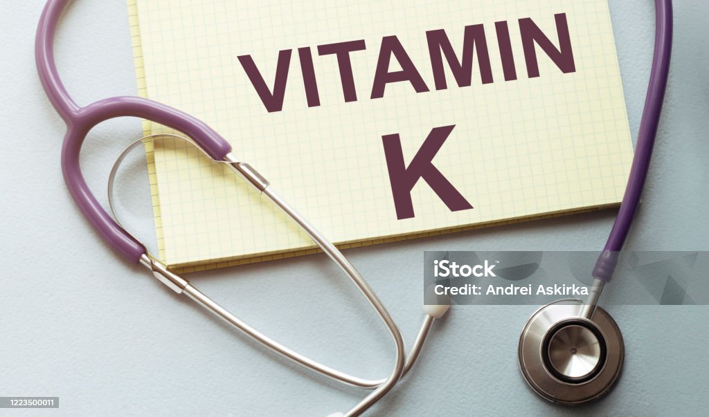 On a purple background a stethoscope with yellow list for you text vitamin k Letter K Stock Photo