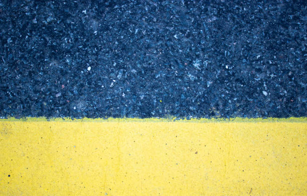 istock A rough look of asphalt with a pronounced yellow stripe horizontally from below. 1223500743
