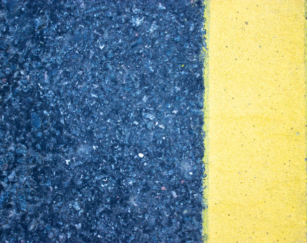 istock A rough look of asphalt with a pronounced yellow stripe vertically on the right. 1223500749