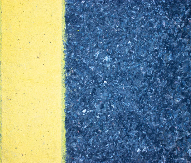 istock A rough look of asphalt with a pronounced yellow stripe vertically on the left. 1223500755