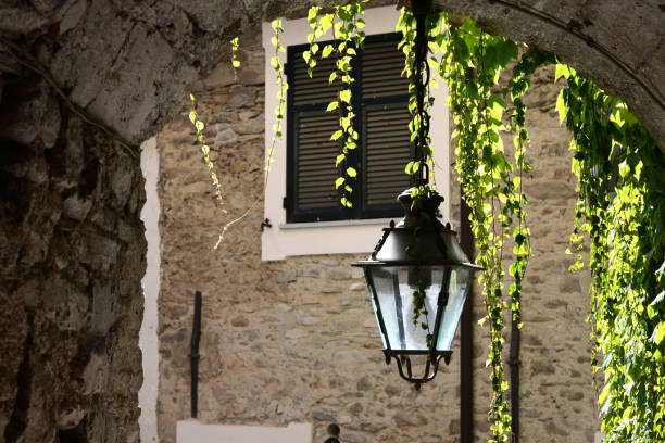 old fashioned street lamp with sunlit leaves in mediterranean city