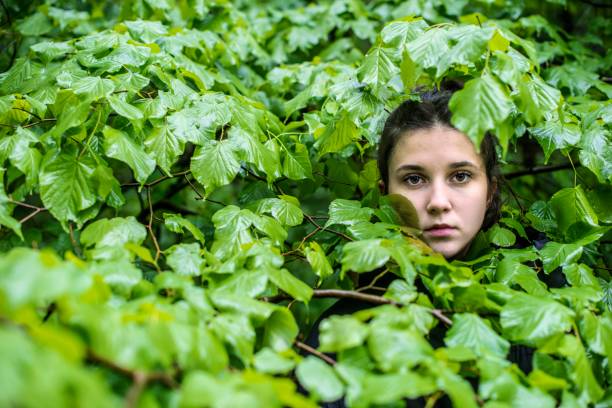 istock A young girl hiding in the forest 1223503804
